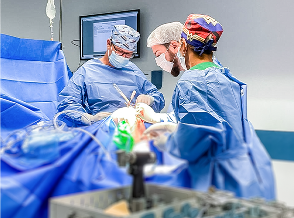 Em uma sala de cirurgia com Dr Gustavo realizando uma cirurgia no joelho de um paciente Foto cirurgia